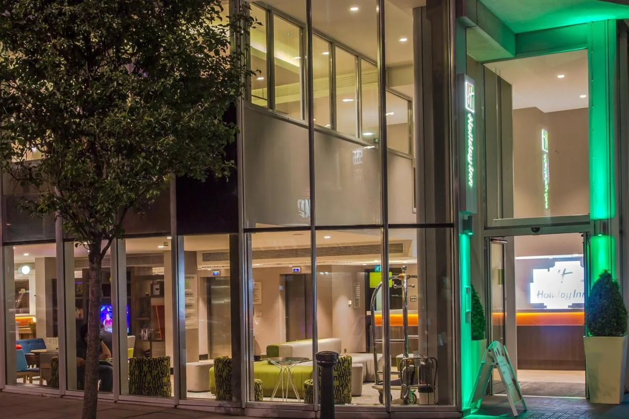a large glass building with a tree in front of it at Holiday Inn London Camden Lock by IHG in London